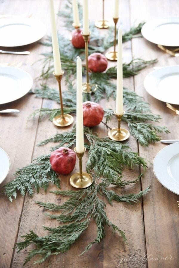 Festive Christmas table runner adorned with pomegranates and greenery, perfect for creating an elegant centerpiece.