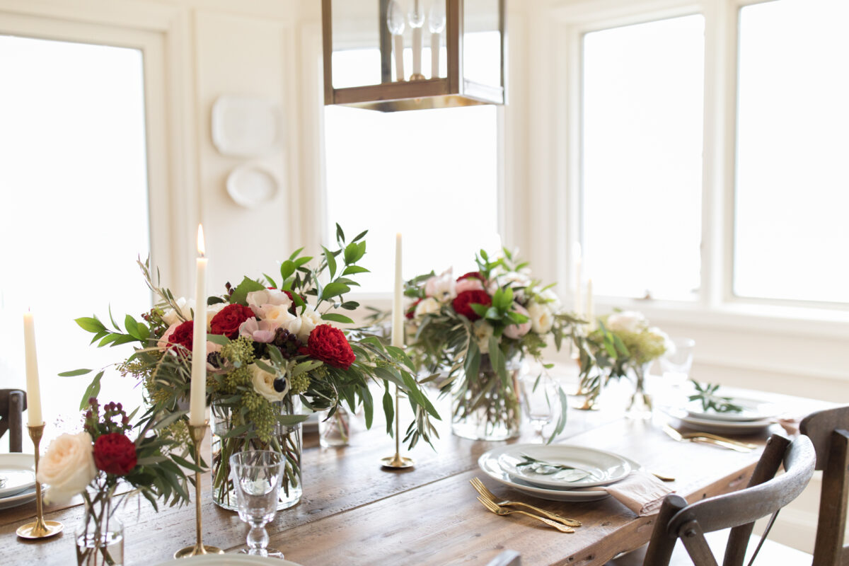 The dining room table is beautifully decorated with a festive Christmas centerpiece, featuring flowers and candles.