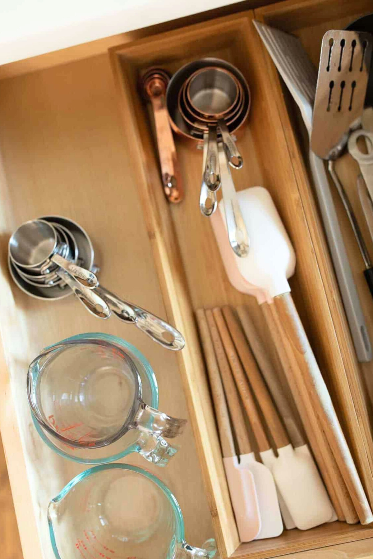 A drawer full of kitchen utensils and silverware drawer organizers.