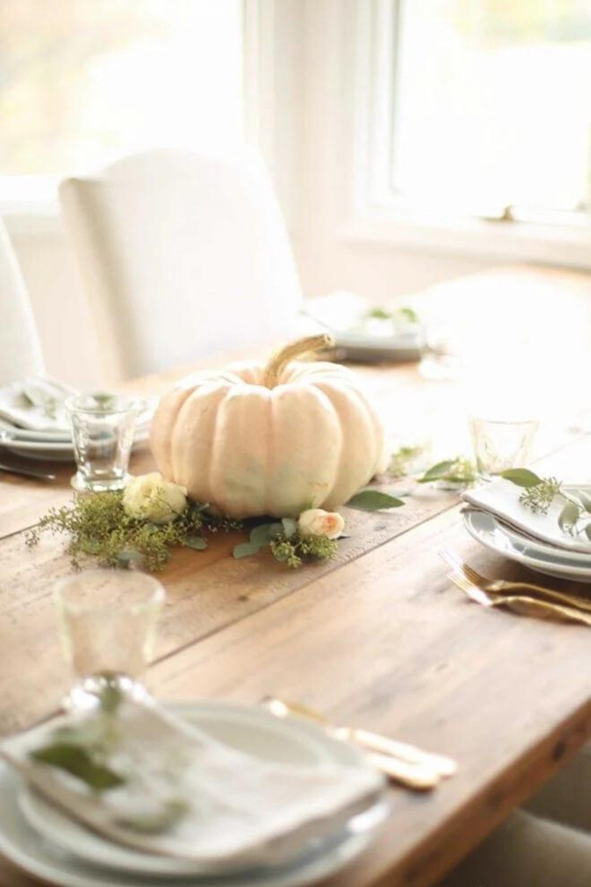 A fall centerpiece made of heirloom pumpkins on a farm table. 