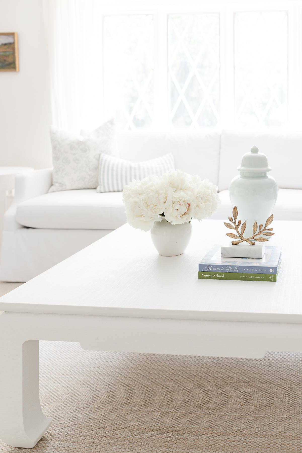 A white coffee table with ginger jars in a living room.