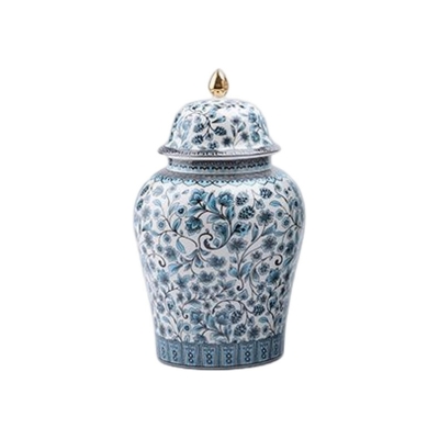 A blue and white porcelain urn with a gold lid.