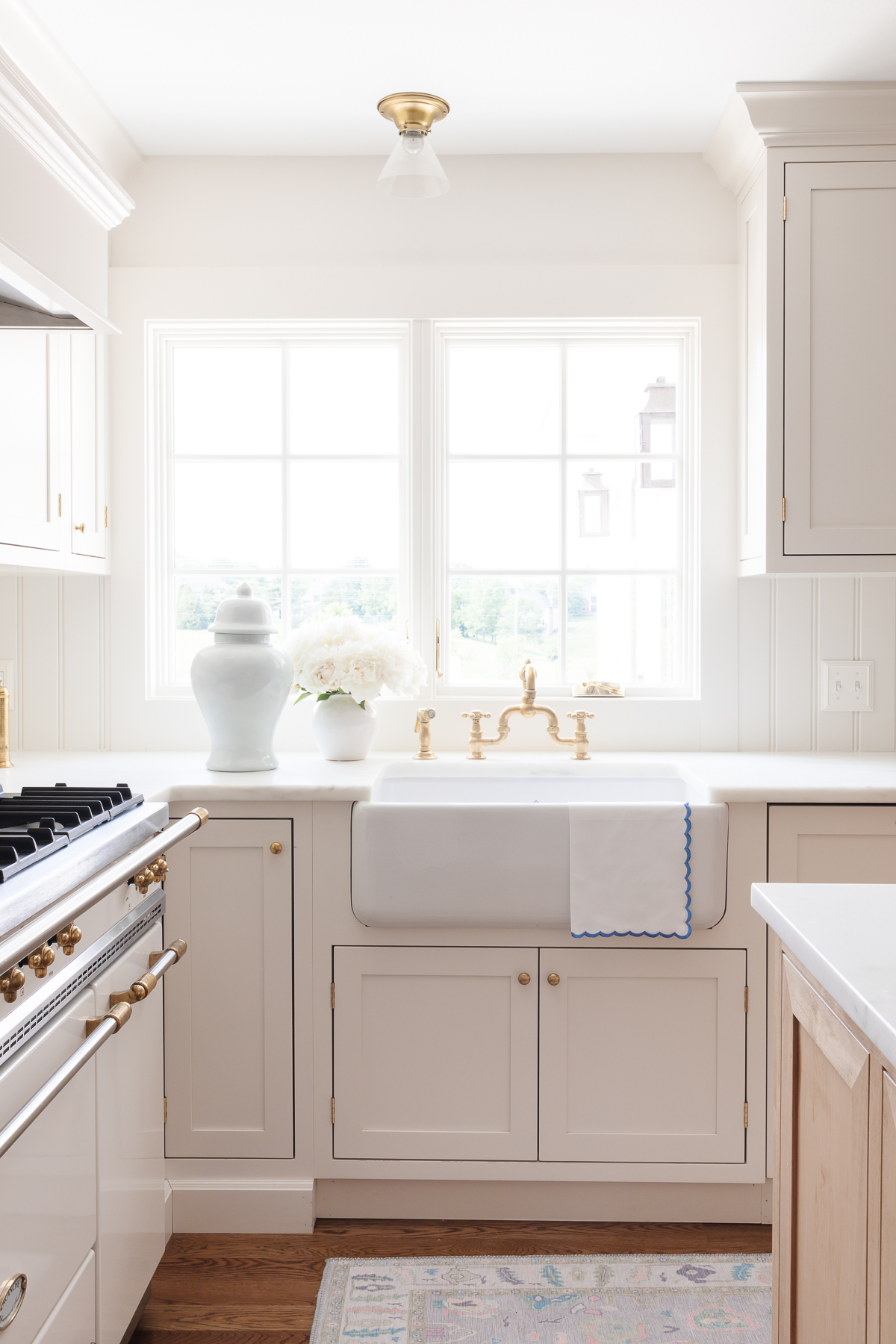 A kitchen with white cabinets and a white sink.