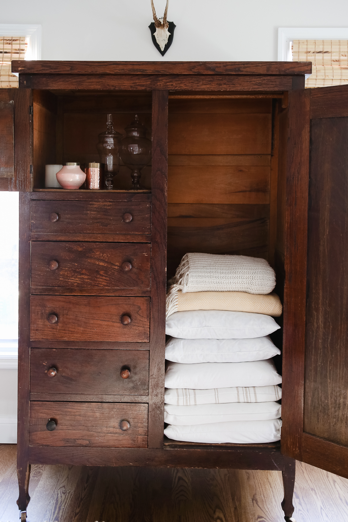 A home organization armoire filled with towels and linens.