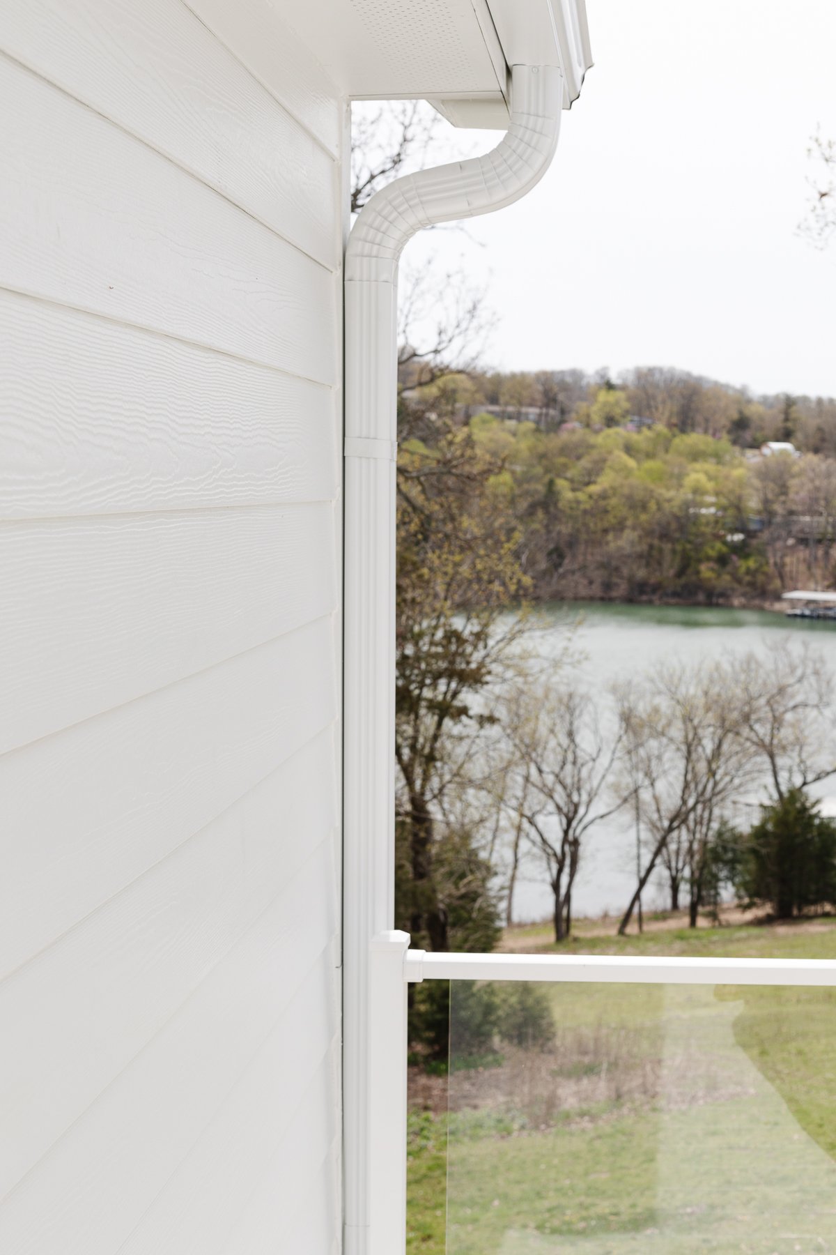 A home with arctic white siding and a view of a lake.