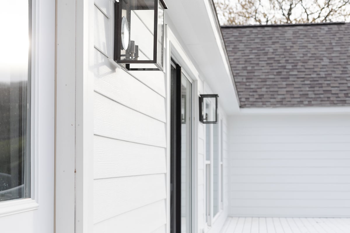 A white house with a black door and James Hardie Arctic white siding.