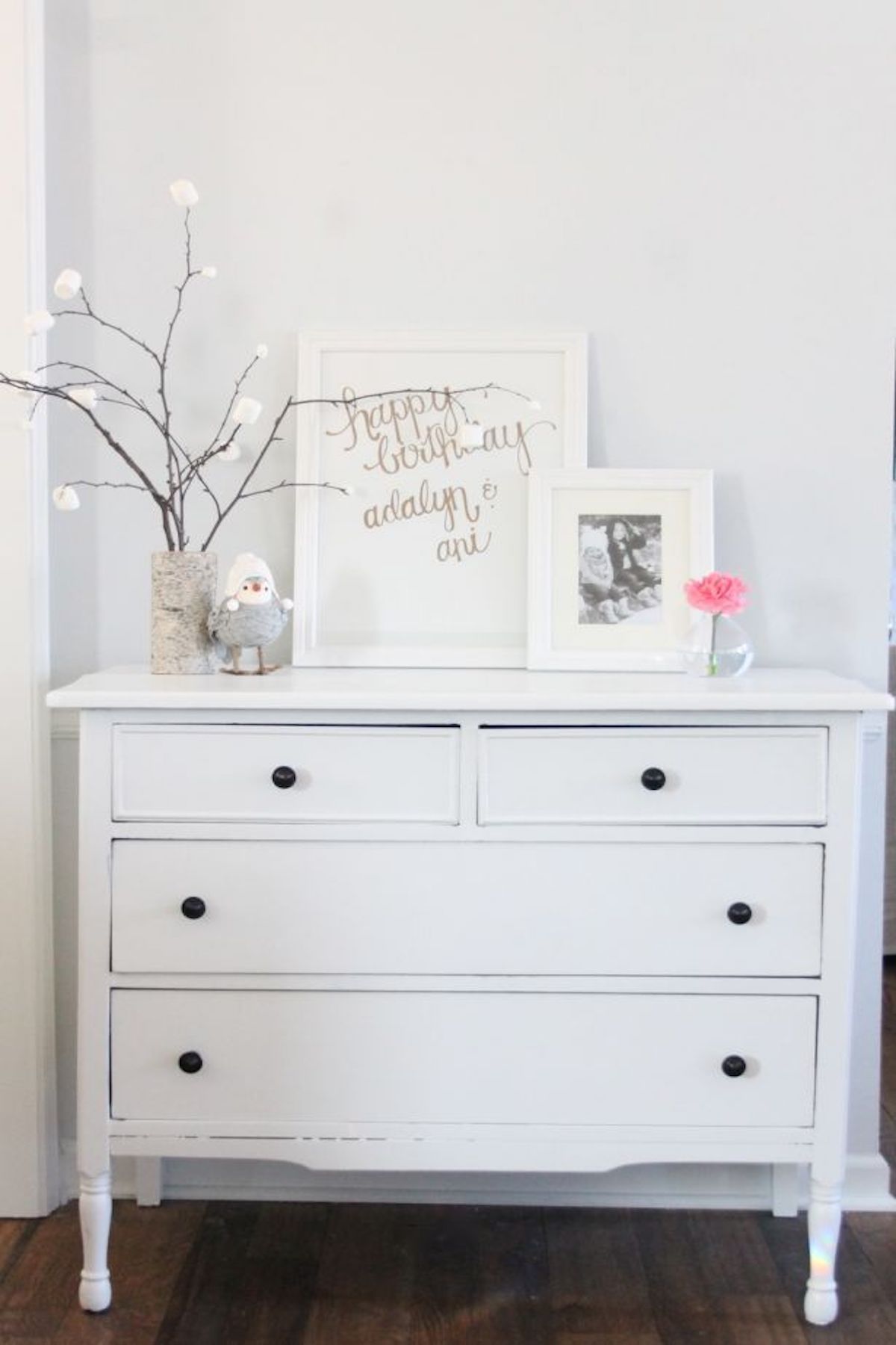 A white dresser adorned with a picture that exudes Christmas magic.