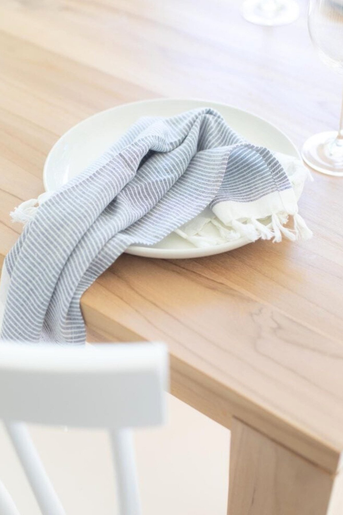 A blue striped napkin on a wooden teak table.