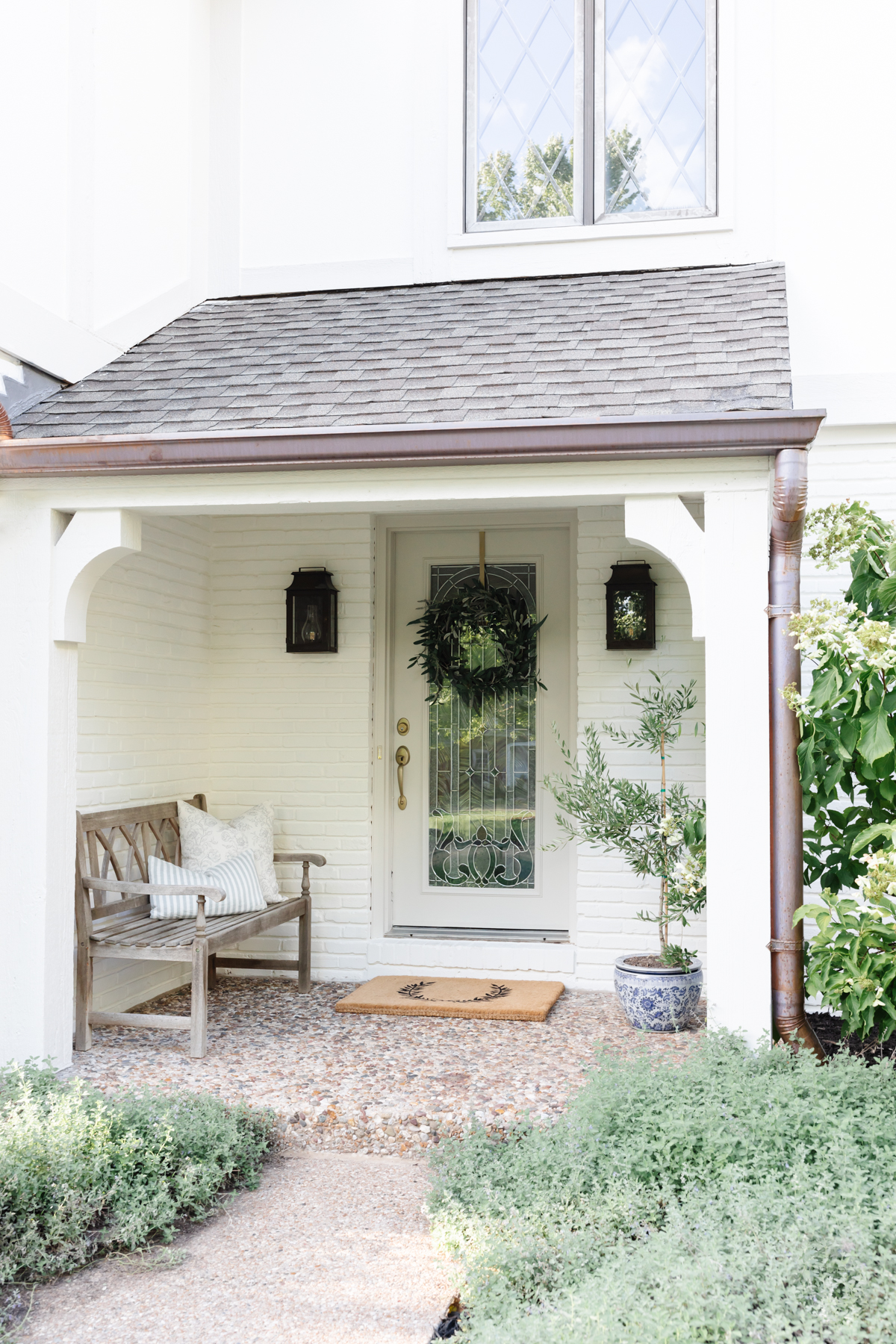A white front porch with plants