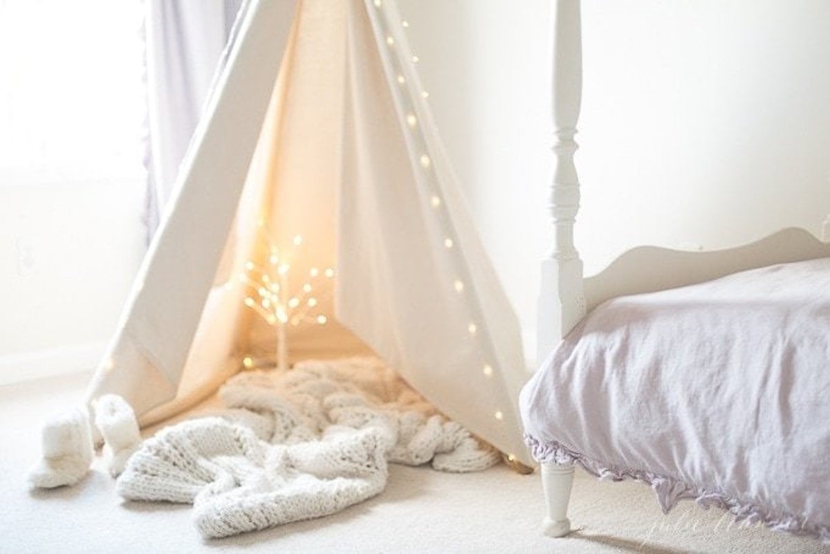 A teepee with a touch of Christmas magic in a girl's bedroom.