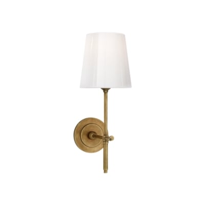 A gold bathroom sconce with a white shade.