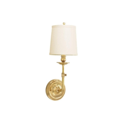 A brass bathroom sconce with a white shade.
