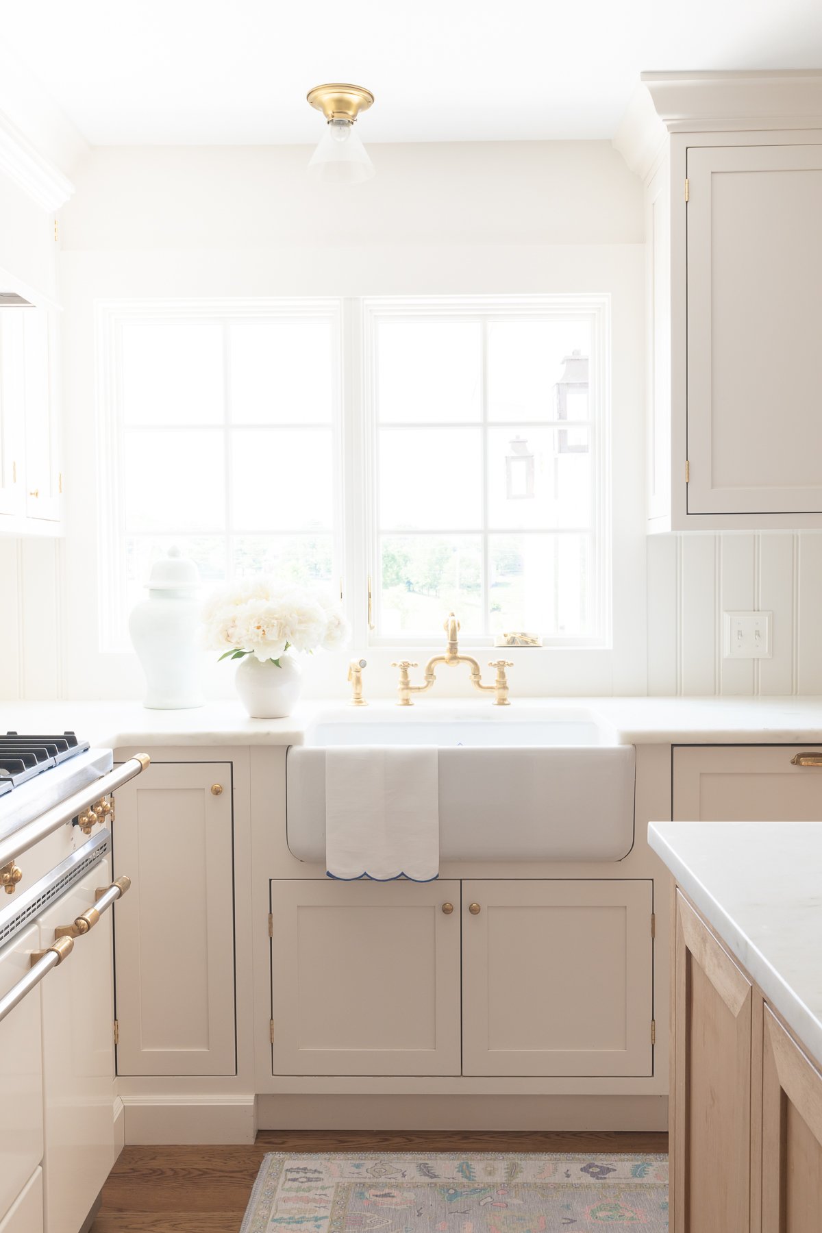 A kitchen with white cabinets and a white sink transformed before and after.