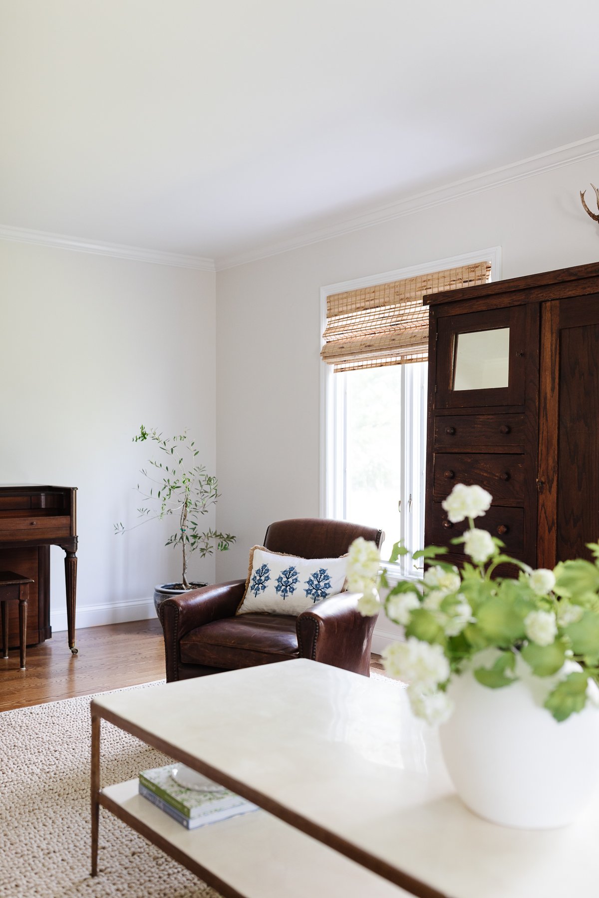 Create a cozy living room with a piano and a vase of flowers, achieving the Pottery Barn look for less.