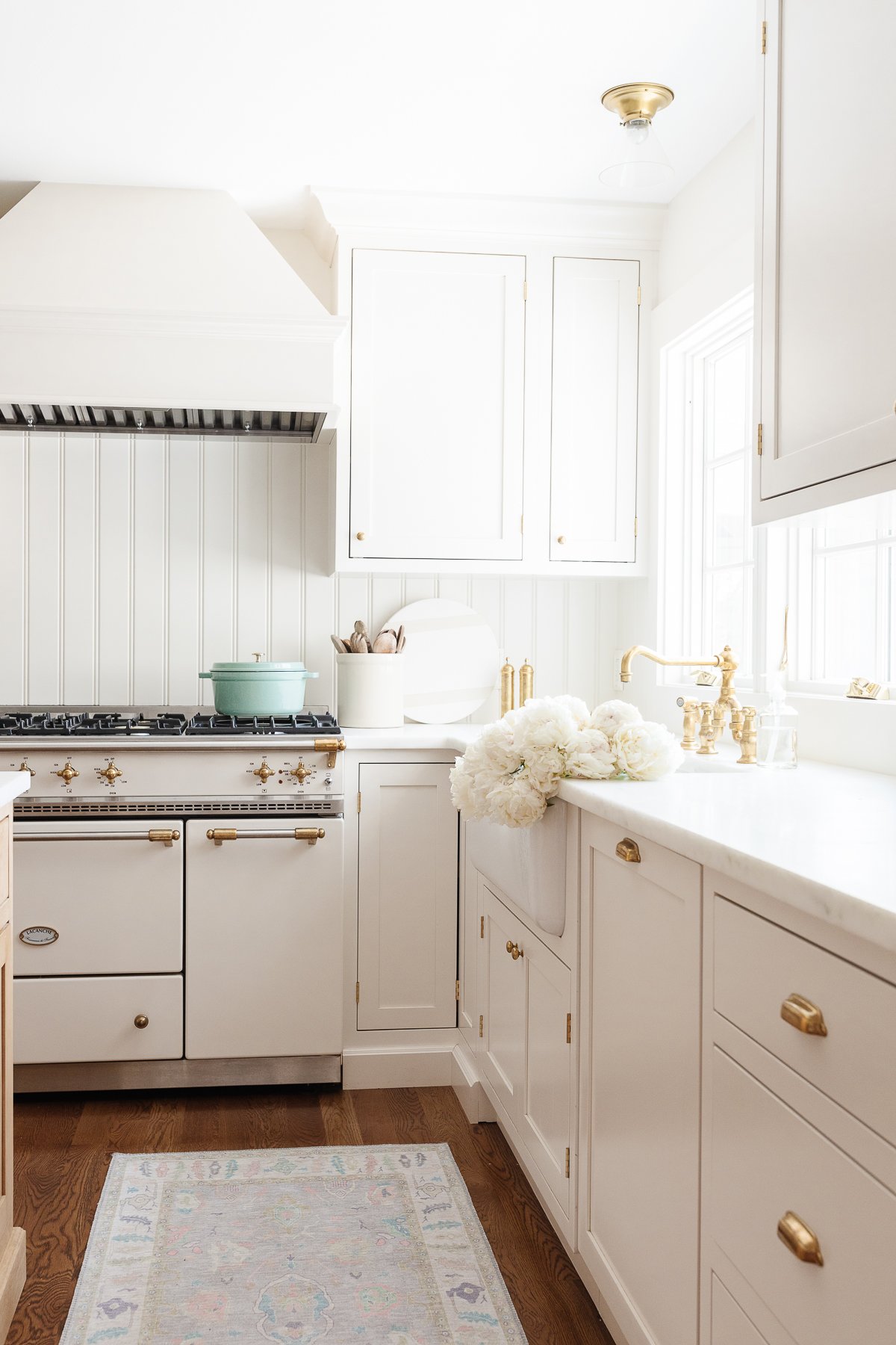 A white kitchen with a rug on the floor