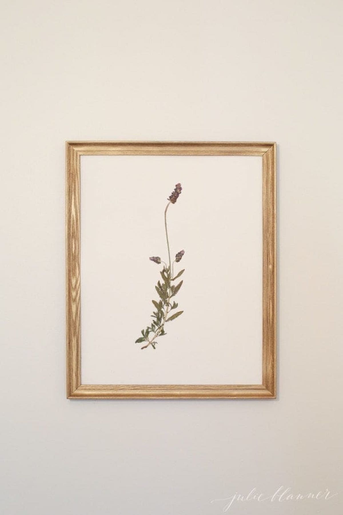 An artful print of a delicate flower hanging above a bed.