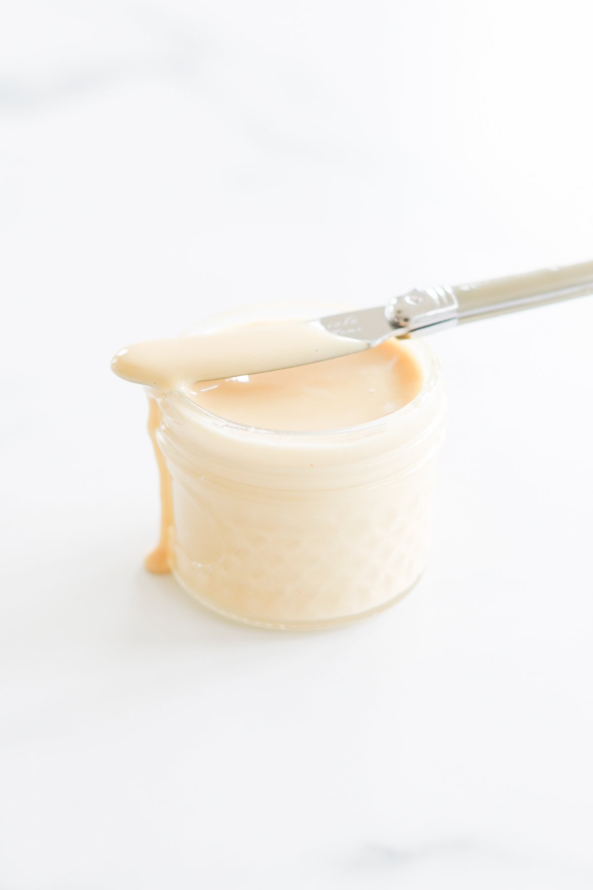 A jar of cream with a spatula on top.