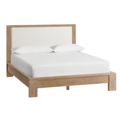 A bed with a wooden frame and white upholstered headboard, offering the RH Look for Less.