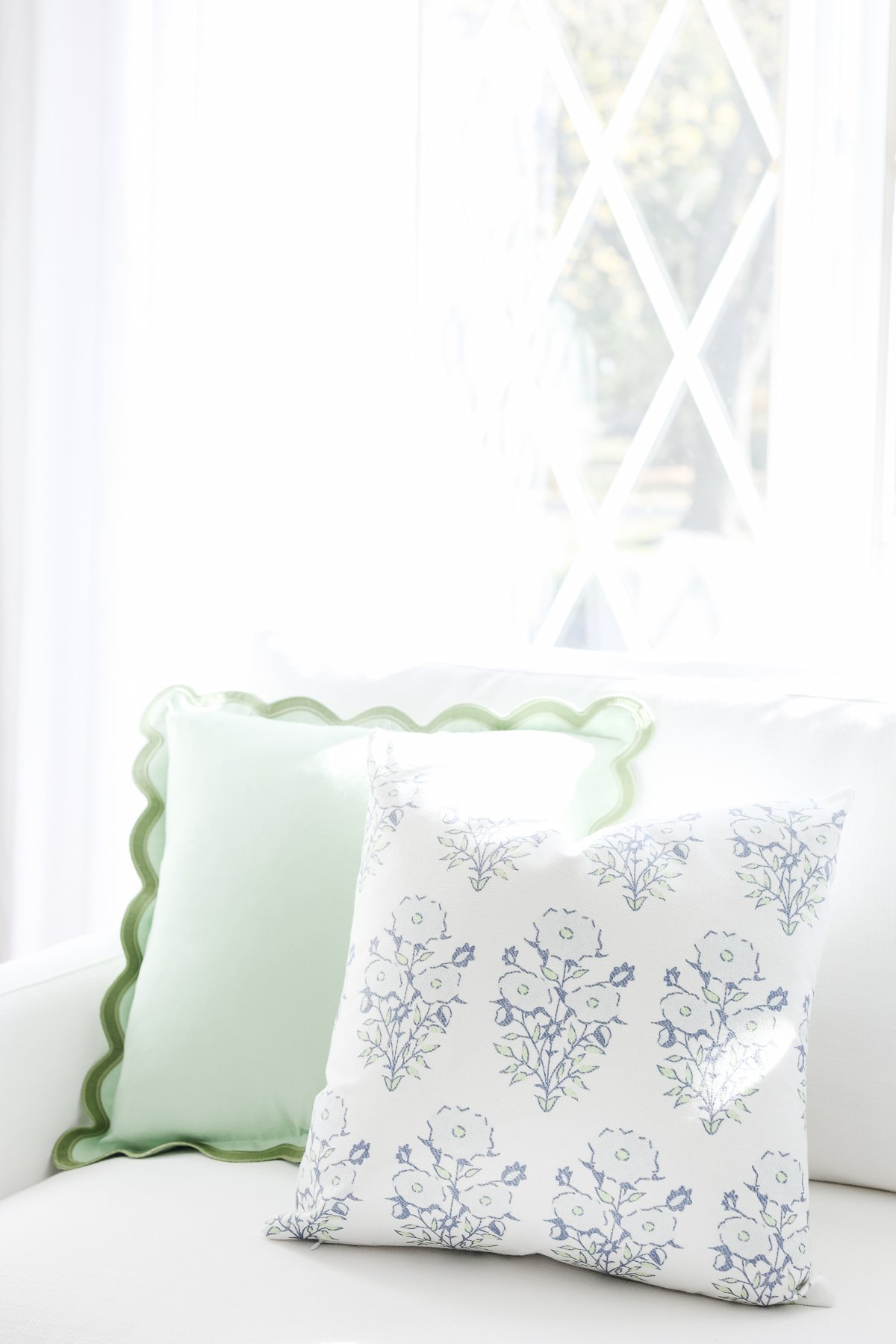 This white couch is adorned with blue and green pillows. Add a touch of color to your living room with these vibrant accents from Amazon pillow covers.
