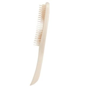 A beige hairbrush with flexible bristles and a curved handle is shown against a white background, making it an exquisite choice for Easter basket fillers.