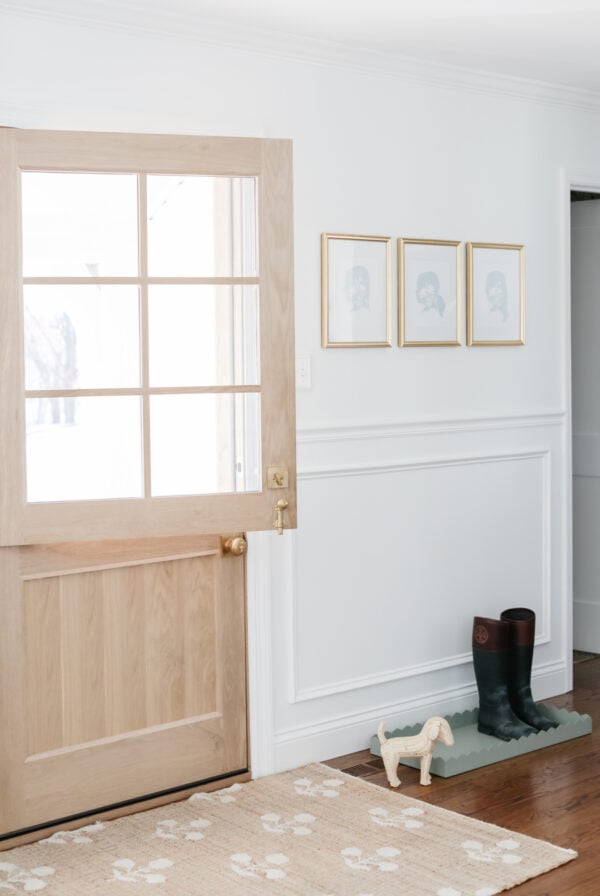 An entryway with a wooden door and a rug, perfect for placing boot trays.