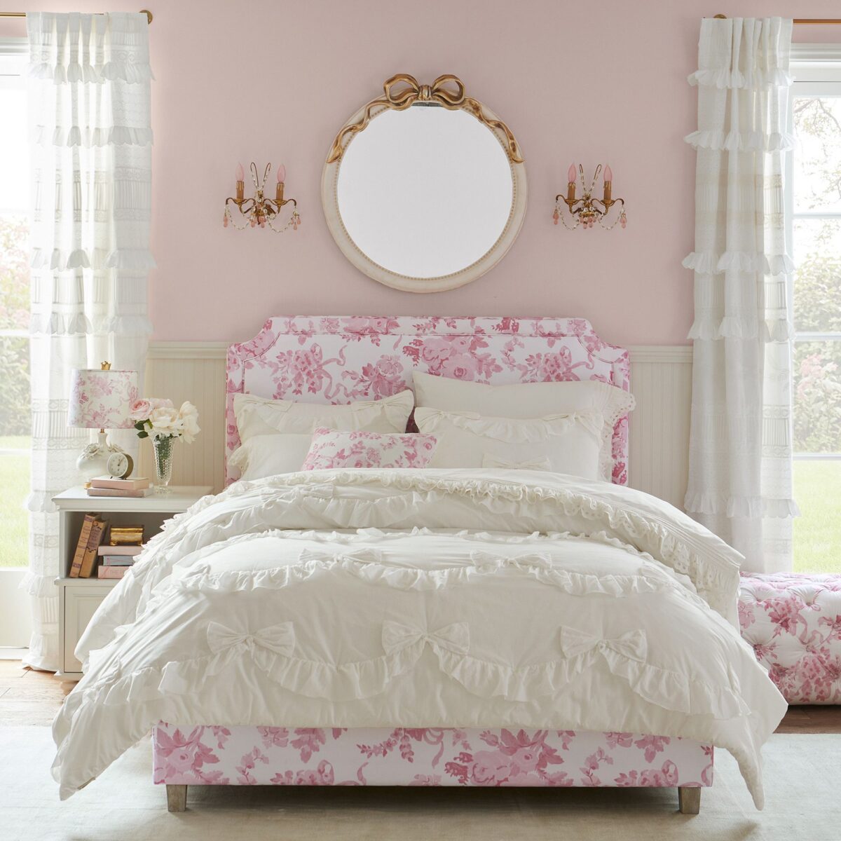 A pink and white tween girl bedroom with a ruffled bed.