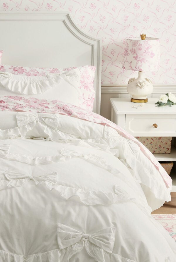 A white and pink bedroom with a ruffled duvet cover, perfect for a tween girl's room.