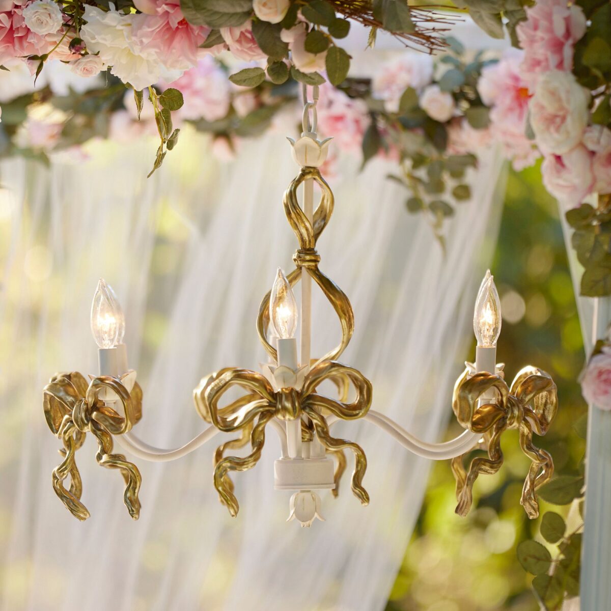 An elegant gold chandelier adorned with delicate pink flowers, perfect for a coquette bedroom.