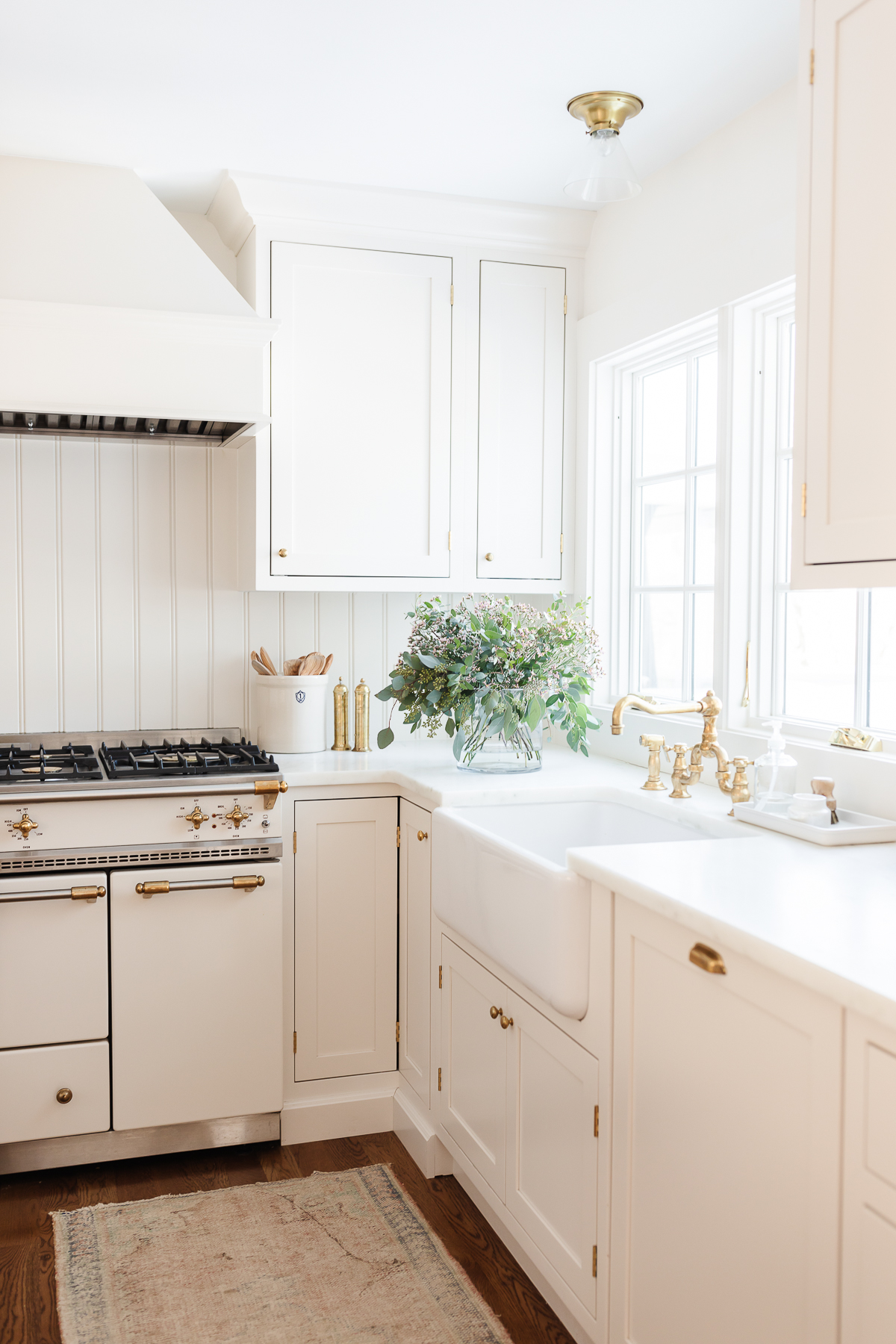 A kitchen with white cabinets and a white stove designed for optimal kitchen organization.