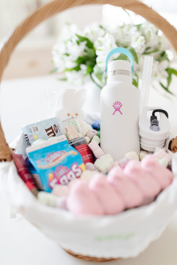 An Easter basket filled with candy and a bottle of water.
