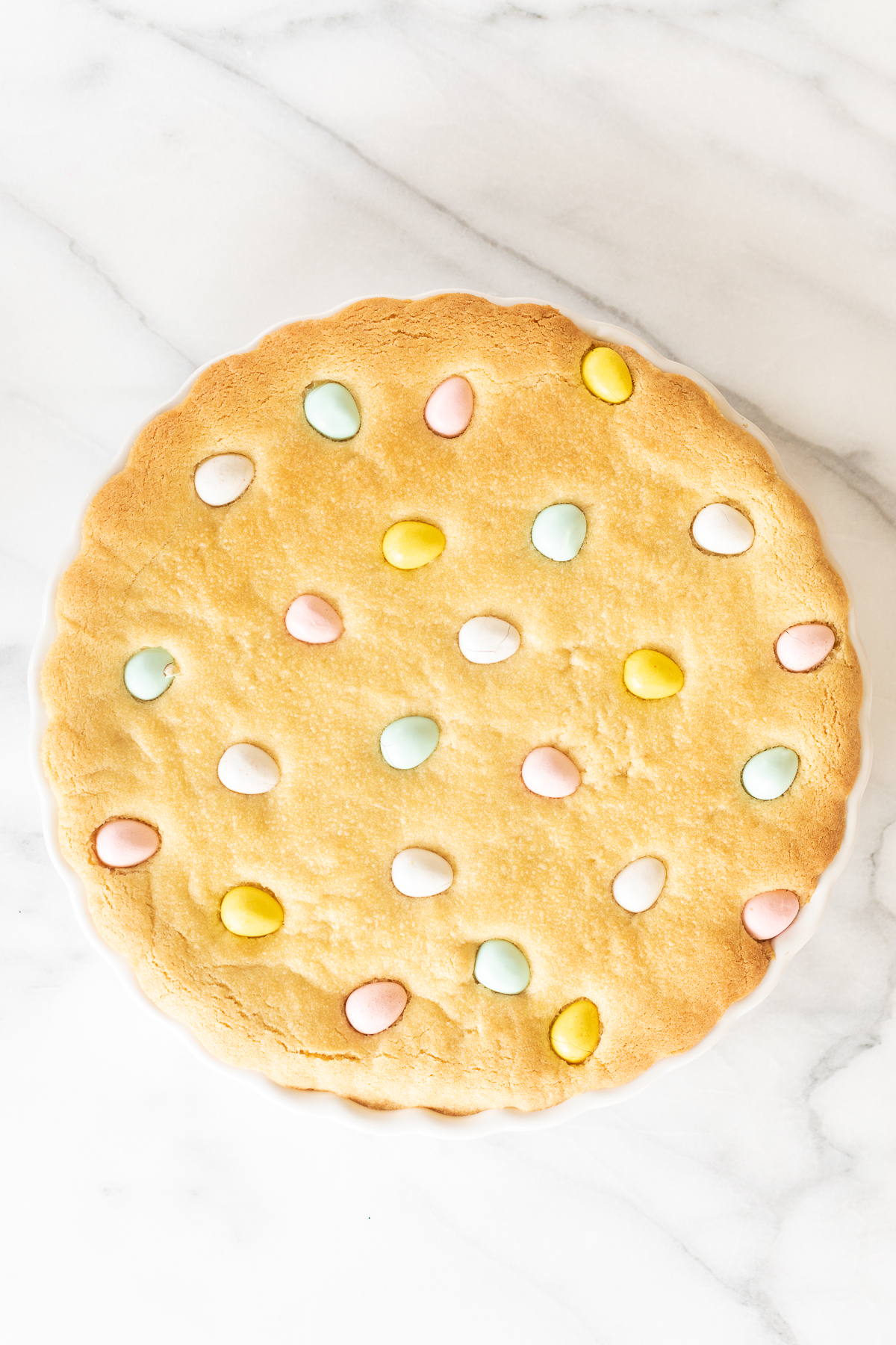 An easter cookie displayed on a white plate.