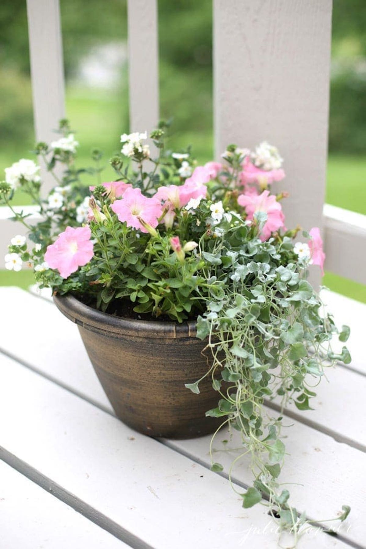 A flower pot on a porch with pink flowers - a perfect example of flower pot design.