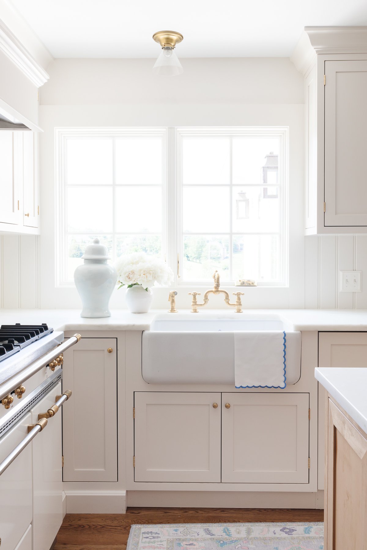 A kitchen with white cabinets and a white sink, featuring under sink storage.