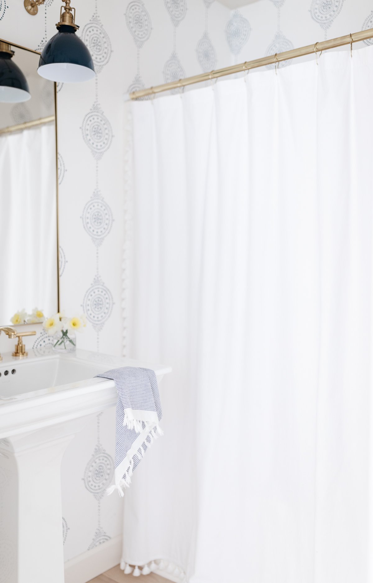 A bathroom with a white shower curtain and a sink, perfect for serena and lily dupes enthusiasts.
