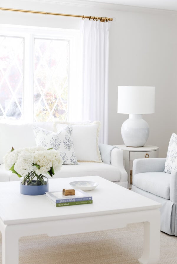 A neutral living room with white furniture.
