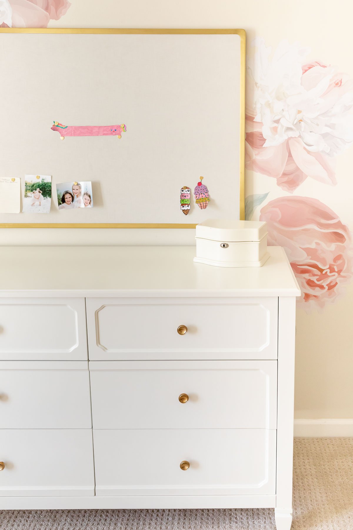 A white dresser with flowers on it.