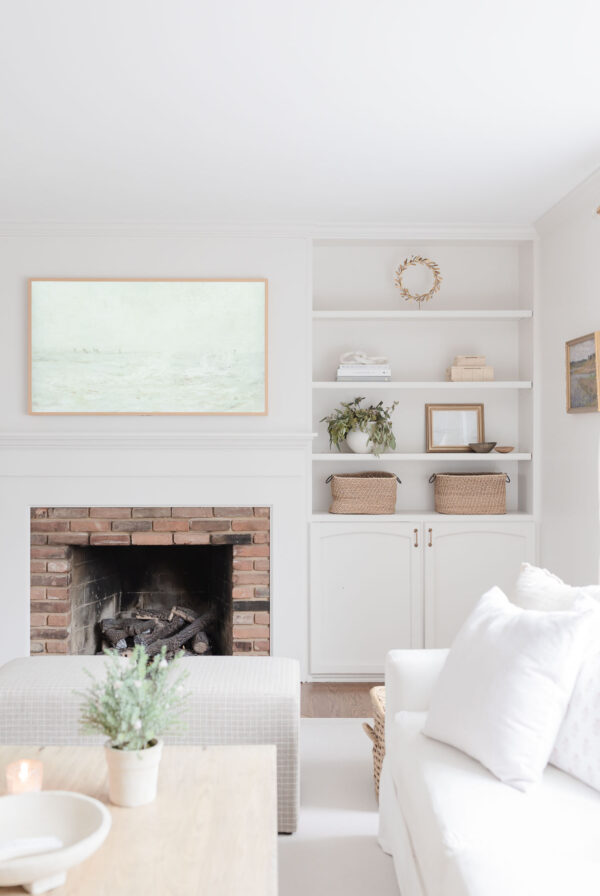 a neutral living room with a Samsung Frame TV over the brick fireplace