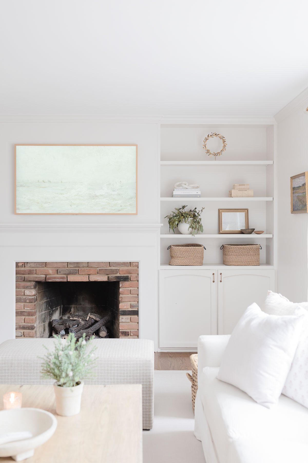 A living room with white furniture, a Samsung Frame TV, and a fireplace.