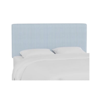 A bed with a blue and white striped headboard reminiscent of the Serena and Lily look for less.