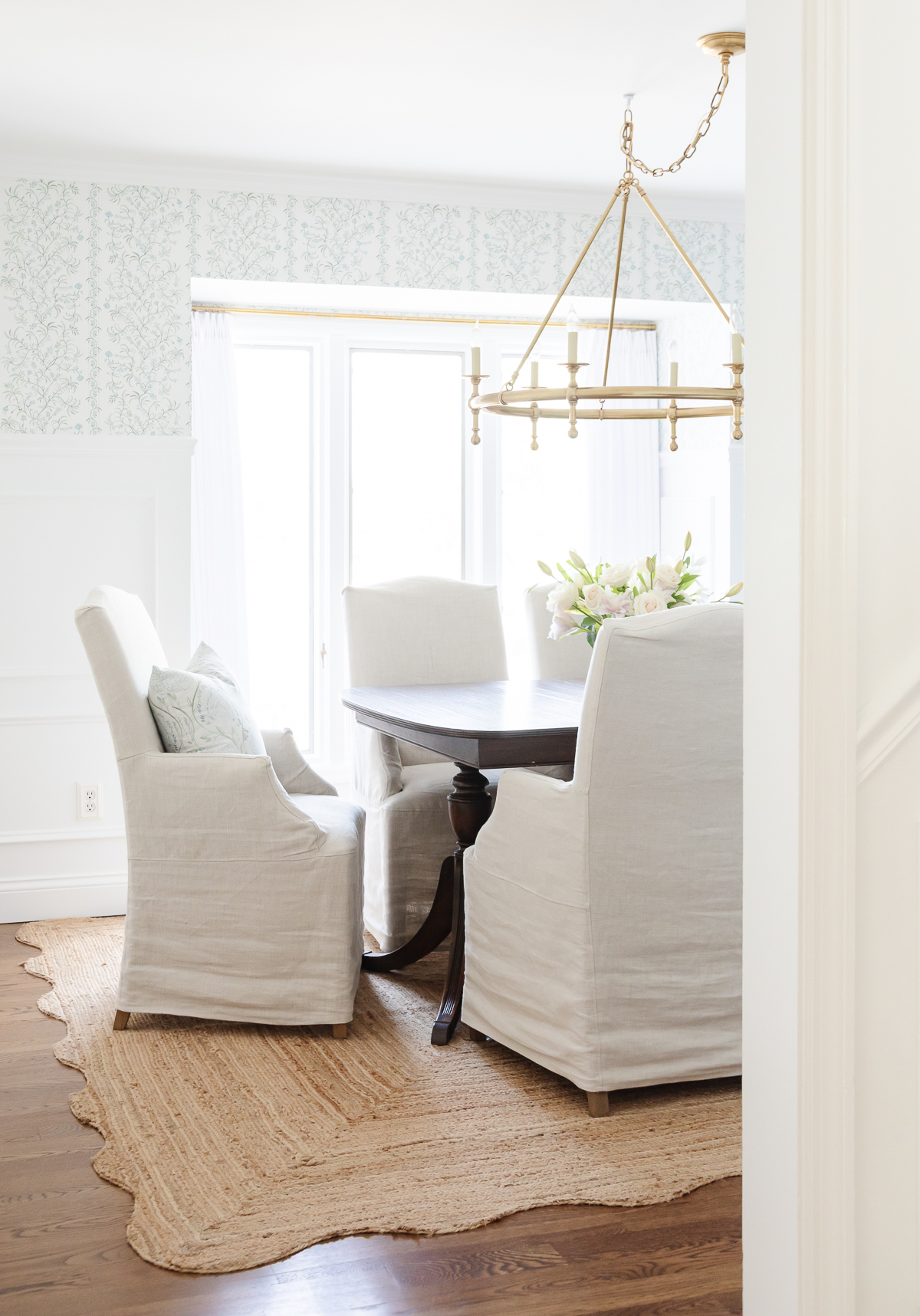 A dining room with a white table and chairs is essential on the house cleaning checklist.
