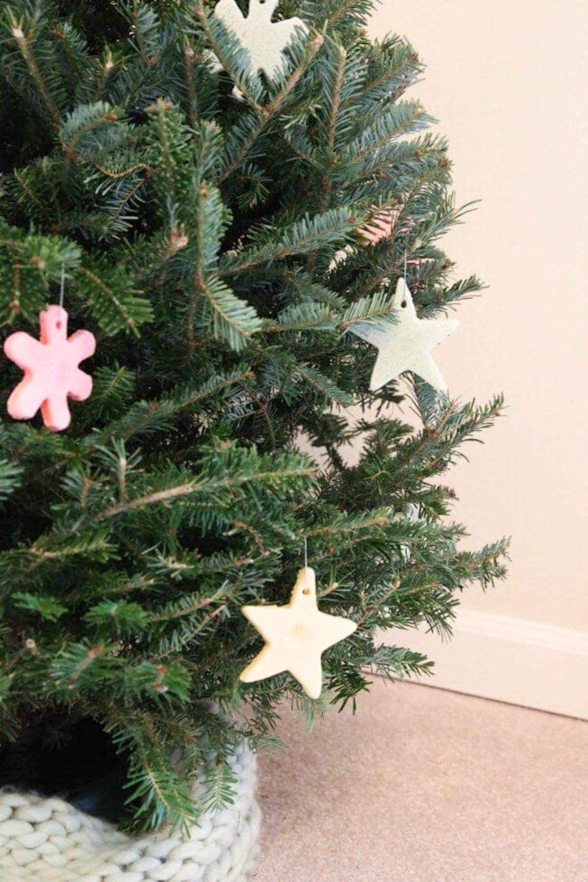 A live Christmas tree decorated with colored salt dough ornaments. 