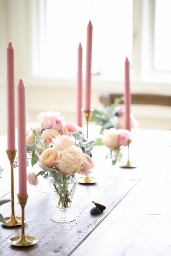 Low vases and pink candle sticks on a long table