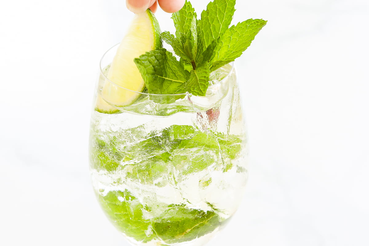 A refreshing Hugo Spritz garnished with lemon and mint leaves.