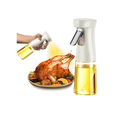 Hand utilizing kitchen gadgets to spray oil from a bottle onto a roasted chicken on a plate.