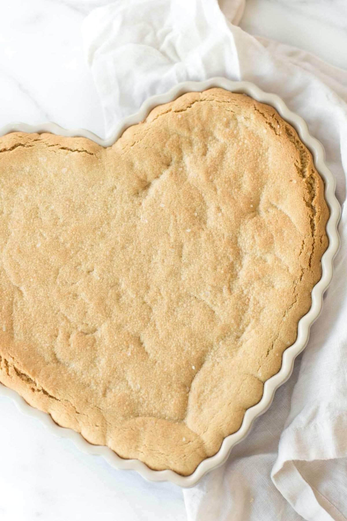 A heart-shaped peanut butter cookie in a white dish.
