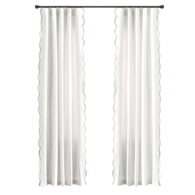 A pair of white curtains with scalloped blue trim.
