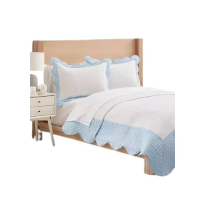 A neatly made bed with a light wooden headboard, white and light blue bedding, and a bedside table with a lamp offers a serene and lily look for less.