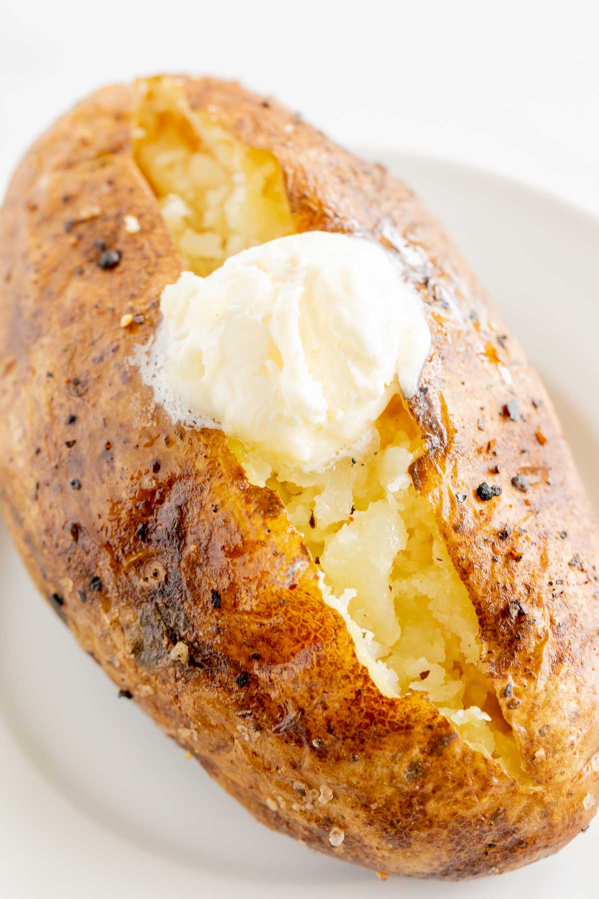 A baked potato on a white plate