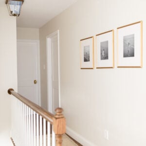 A long hallway with white doors, wood floors, and a cream paint color on the walls.
