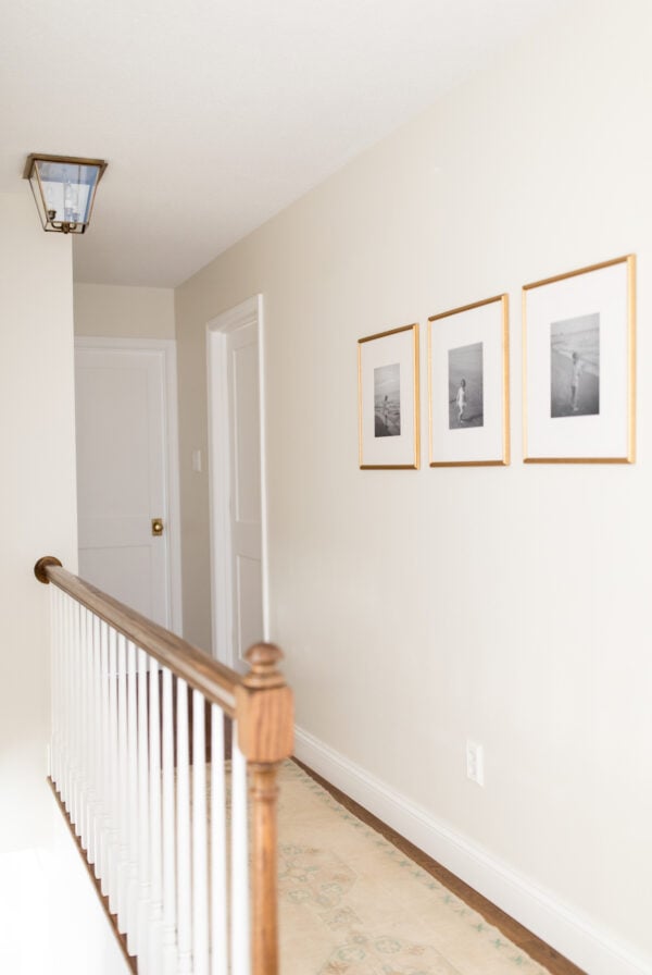 A long hallway with white doors, wood floors, and a cream paint color on the walls.